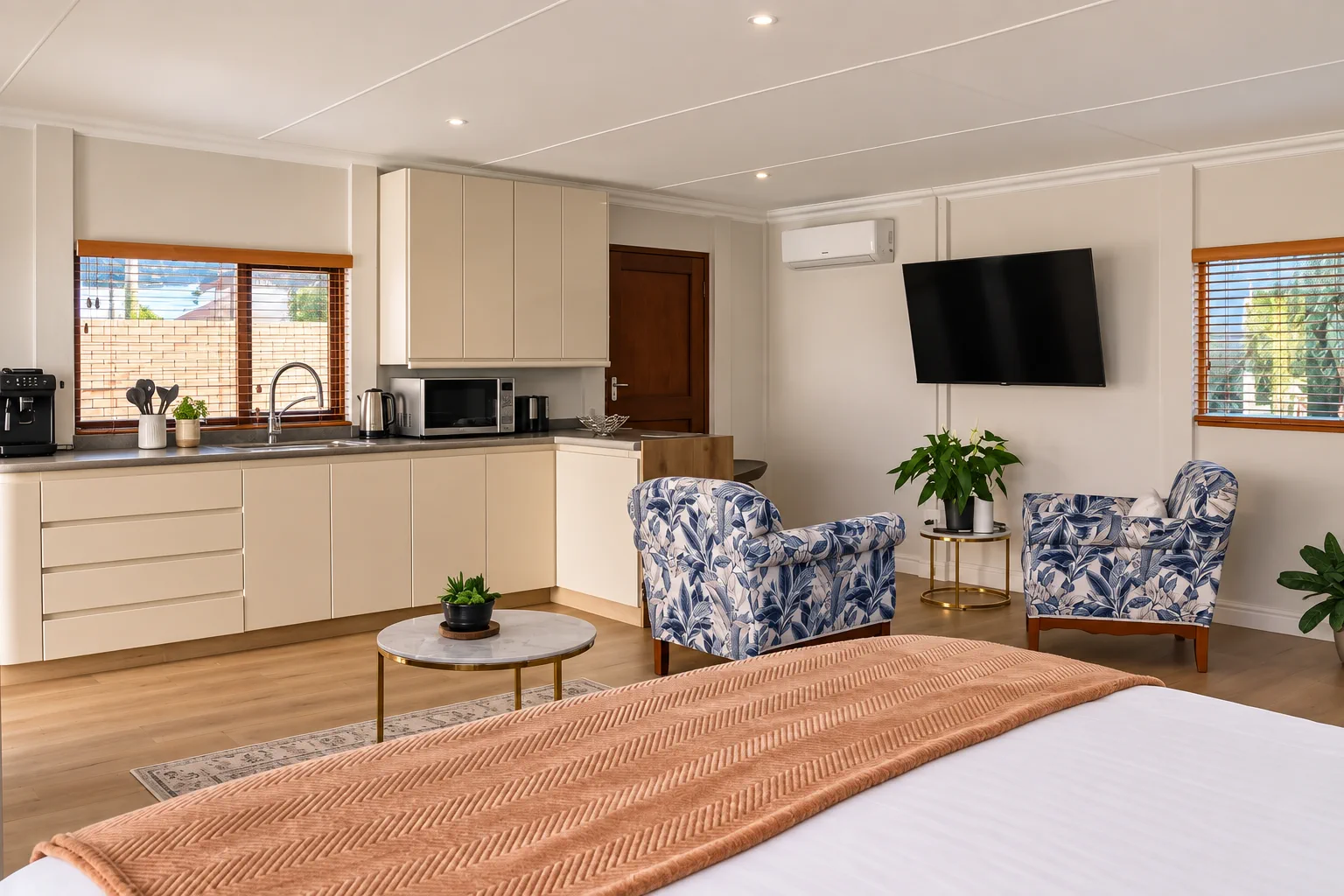 Kitchenette, seating and Smart TV from the bed